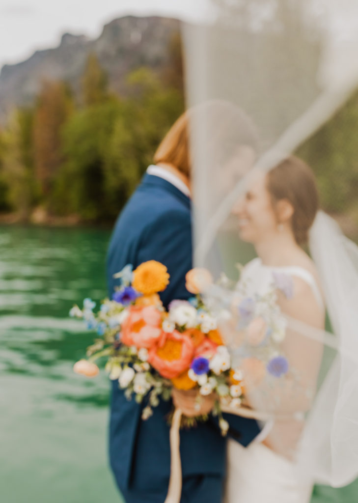 Bride and Groom during Lake McDonald Elopement. Bright wedding bouquet.