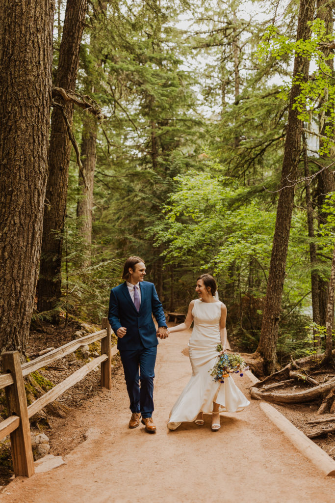 Bride and groom hiking in Glacier National Park after Lake McDonald elopement.