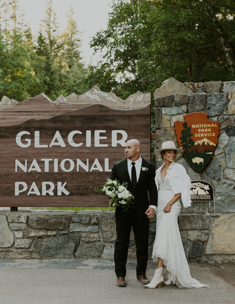 Glacier National Park Elopement photo by Haley J Photo - Photo in front of the Glacier National Park entrance sign