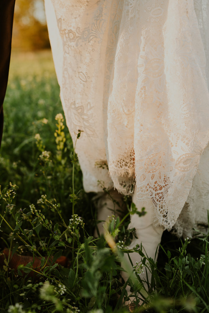 Close up detail of the brides shoes and dress in a grass field. Glacier National Park Photography by Haley Jessat