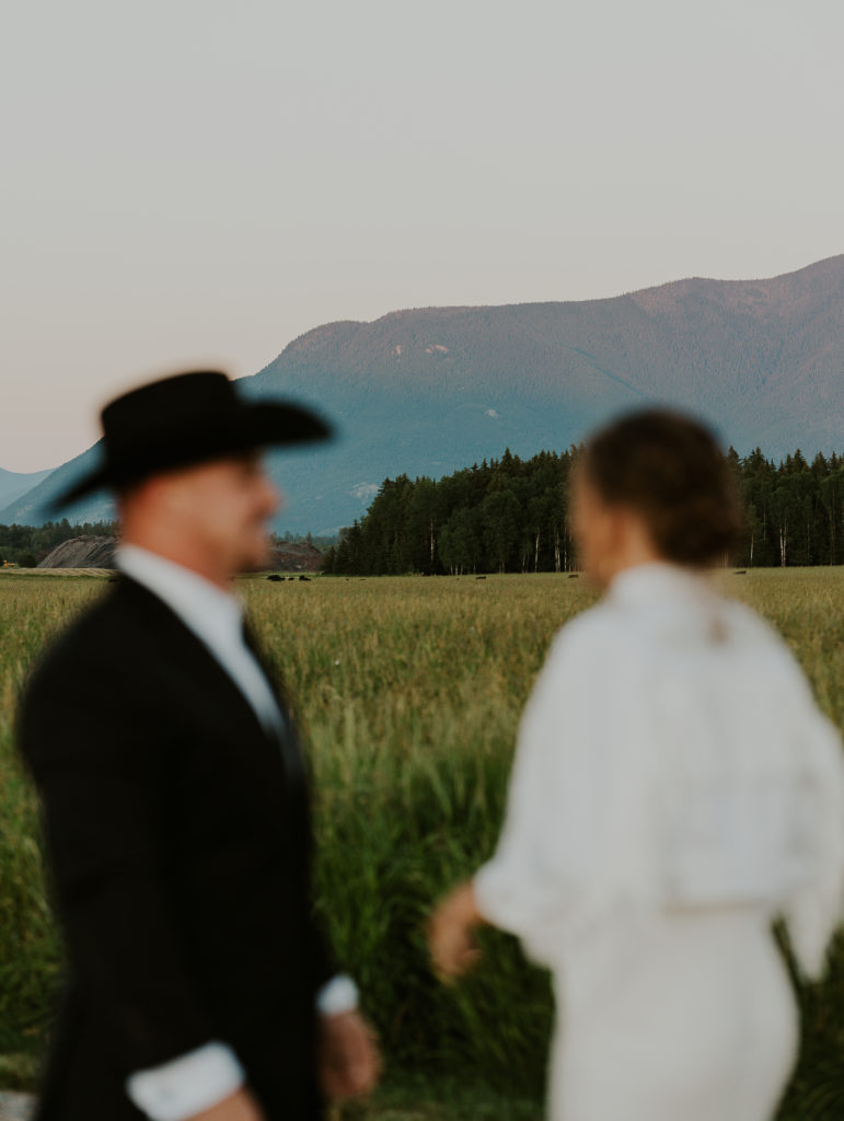 Glacier Raft Co Elopement near Glacier National Park. Bride and groom. Bride is wearing a jean jacket with tassels and last name on jacket. Glacier National Park Photography by Haley Jessat