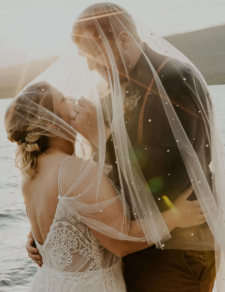 Bride and groom under a bridal veil. Wedding photography by HaleyJPhoto