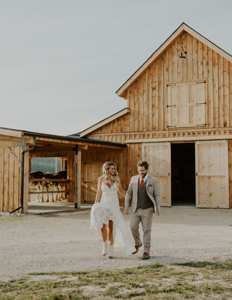 Bride and groom in front of barn at Clydesdale Outpost | Whitefish, Montana Wedding Venue
