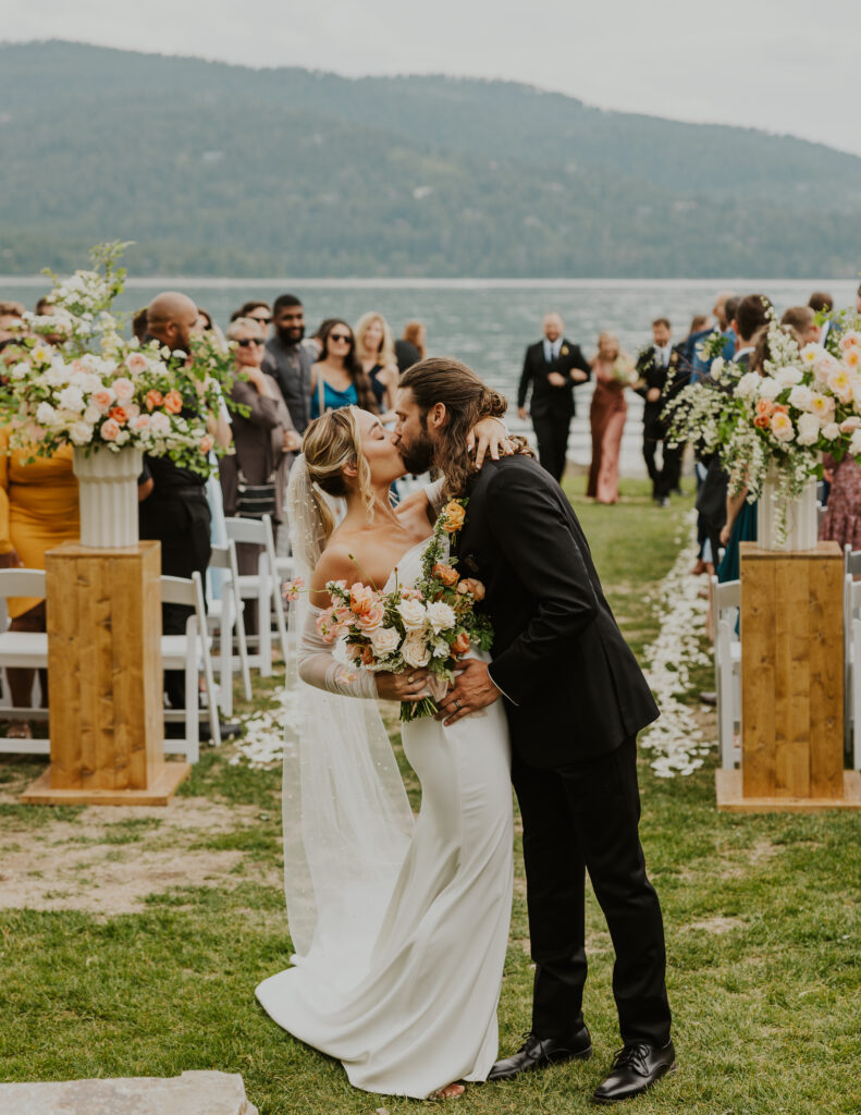 Bride and groom walking down the isle at The Lodge at Whitefish Lake wedding venue. Shot by Haley Jessat