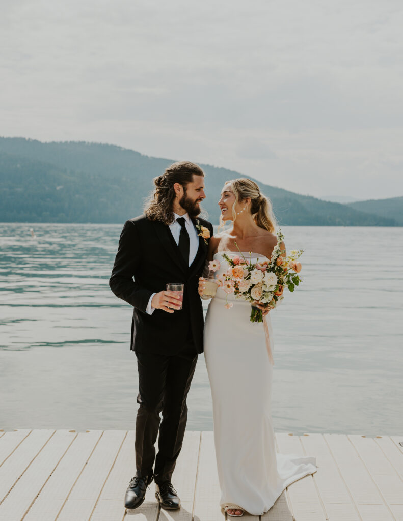 Bride and groom gazing at each other on Whitefish Lake dock