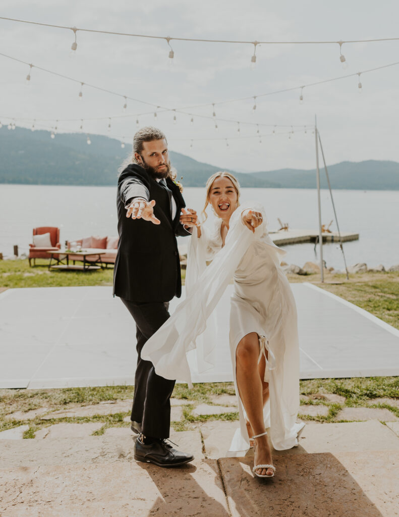 Bride and groom dancing at Whitefish Lake wedding venue. Mountain and lake in the background