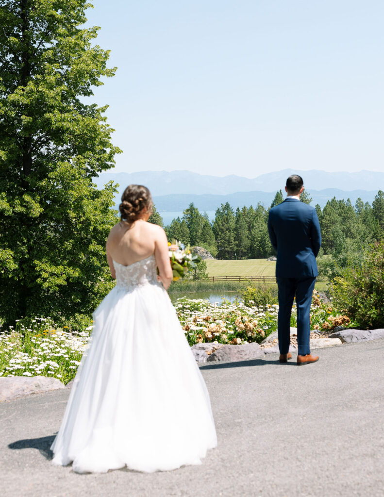 Bride in a strapless white gown walking toward the groom for a first look, surrounded by the picturesque mountain views of Amen Ranch in Montana.