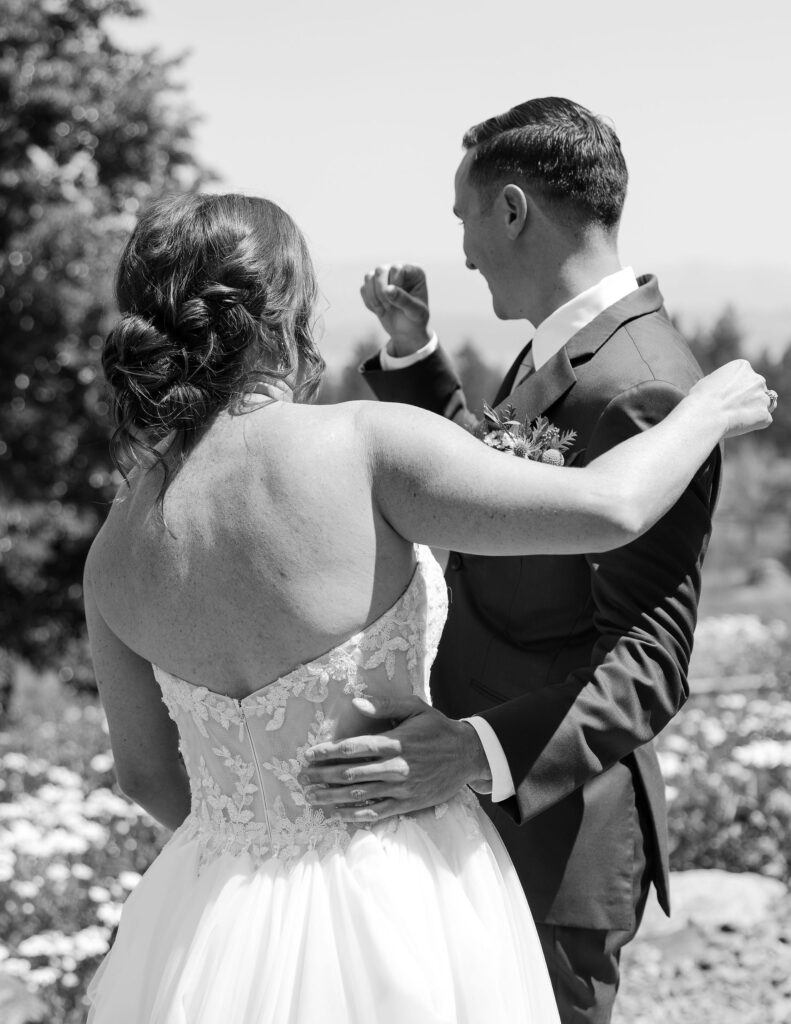 Black and white image of a bride and groom embracing during their first look, showcasing an intimate moment of connection at a Montana wedding venue.