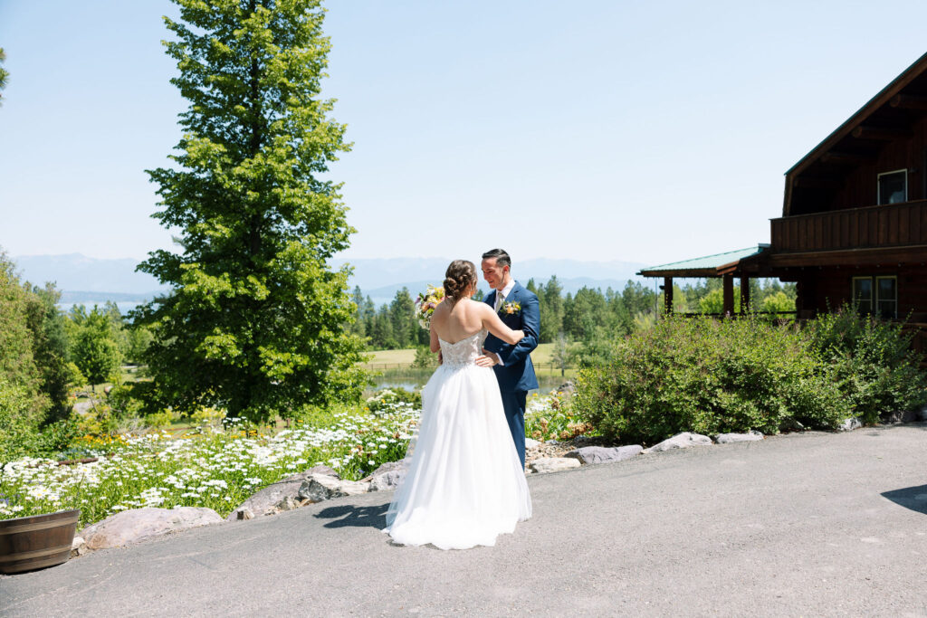 Bride and groom dancing outdoors with a scenic mountain backdrop, sharing a joyful moment during their wedding at Amen Ranch.