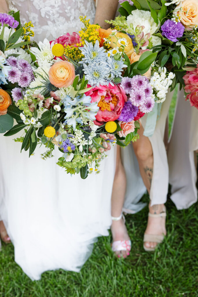 Close-up of a colorful bridal bouquet featuring a vibrant mix of flowers, held by the bride, showcasing the floral arrangements at a Montana wedding venue.