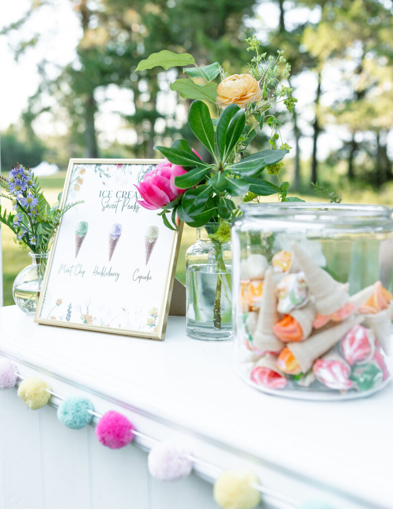 Close-up of a wedding dessert station with colorful decor and a sign for dessert options, adding a playful touch to the wedding reception at Amen Ranch.