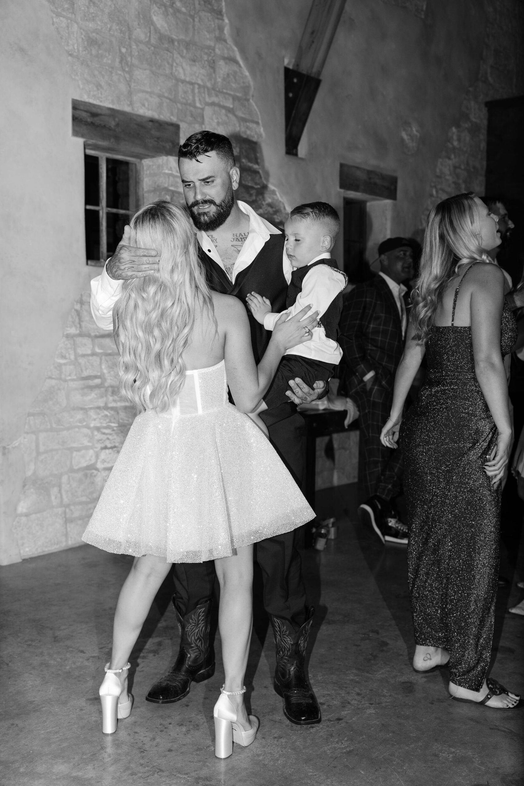 Black and white image of the bride dancing with the groom and a young boy at Copper Rose Ranch Wedding Venue. Captured by Montana Wedding Photographer Haley J Photo.