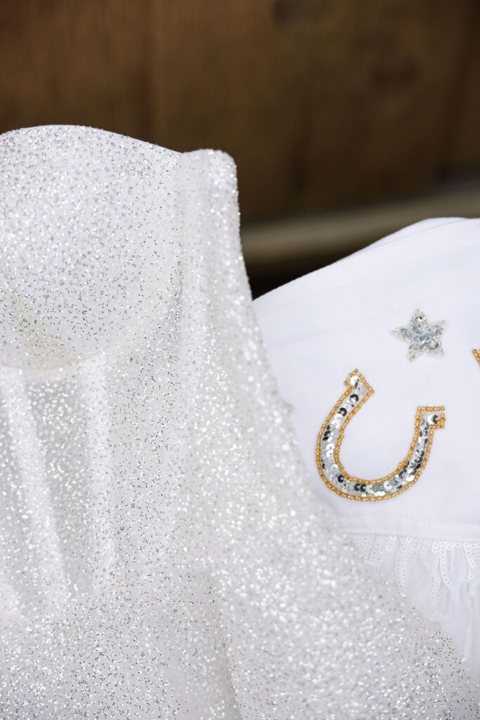 Wedding details, including shoes, invitations, and a floral arrangement, displayed on a round marble table at Copper Rose Ranch Wedding Venue. Captured by Haley J Photo, a Montana Wedding Venue Photographer.