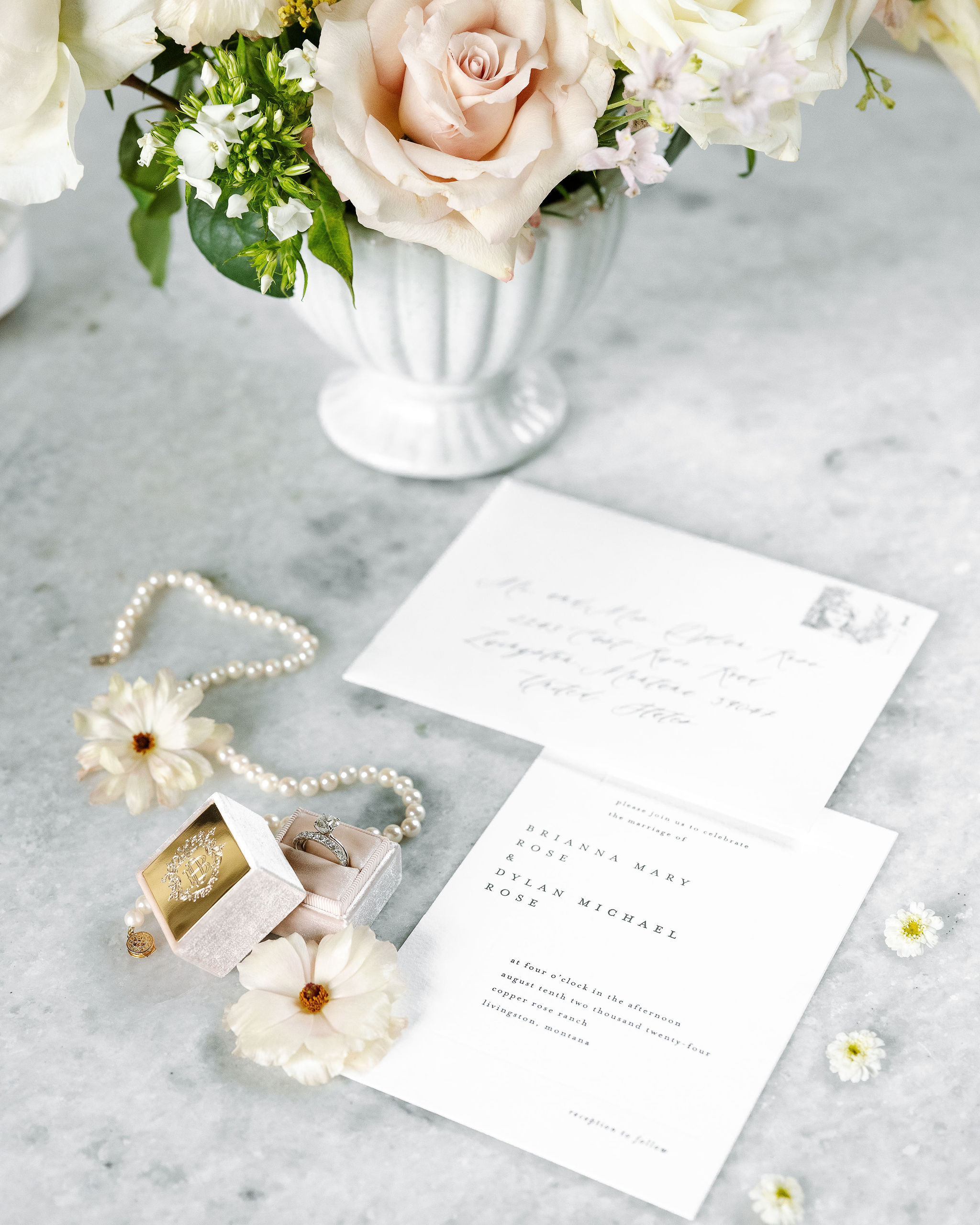 Elegant wedding stationery with floral accents and jewelry, set beside a soft pink and white bouquet. Captured by Montana Wedding Photographer Haley J Photo.