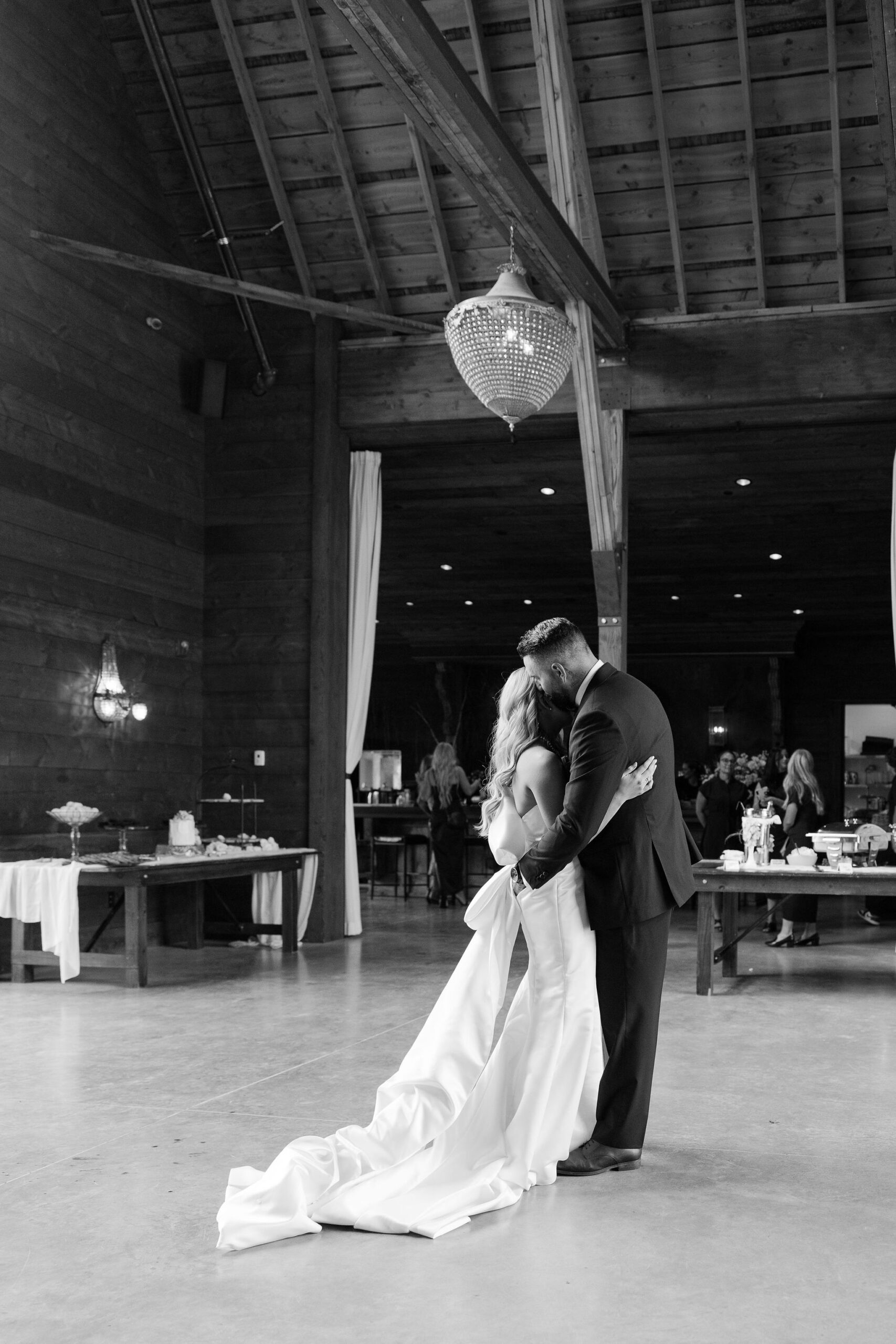 The bride and groom share a quiet moment during their first dance inside the barn at Copper Rose Ranch Wedding Venue in Montana. The black and white image captures the intimacy and elegance of the moment, photographed by Haley J Photo, a Montana Wedding Venue Photographer.