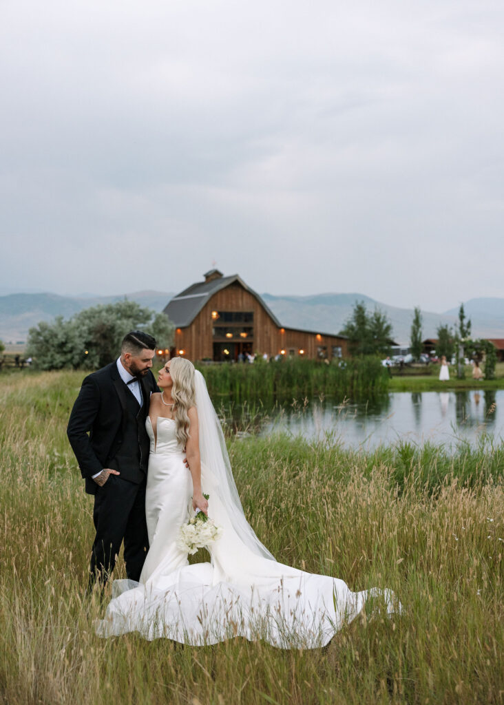 A cozy seating area with wooden benches and potted plants outside the rustic entrance of Copper Rose Ranch Wedding Venue. Captured by Haley J Photo, a Montana Wedding Venue Photographer.