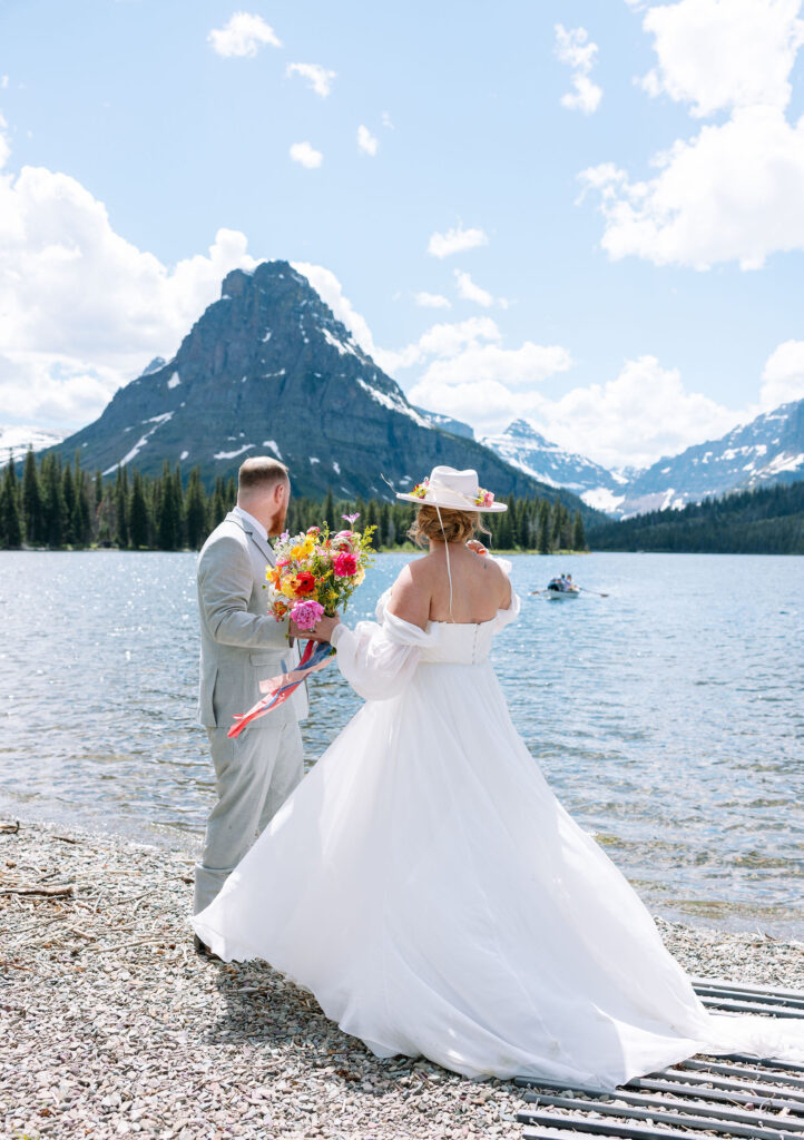 Bride’s veil flying in the air with mountains in the distance, showcasing the dramatic landscape of Glacier National Park