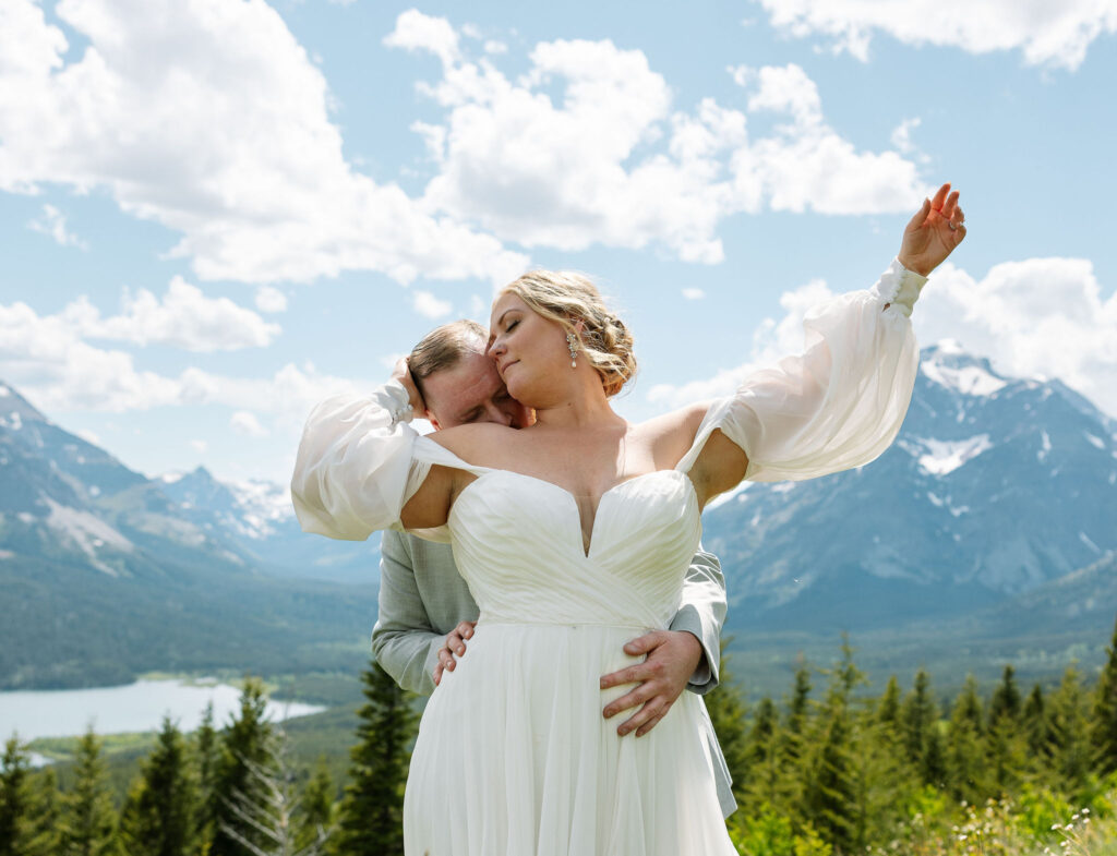 Bride and groom kissing in a scenic outdoor landscape, celebrating their elopement.