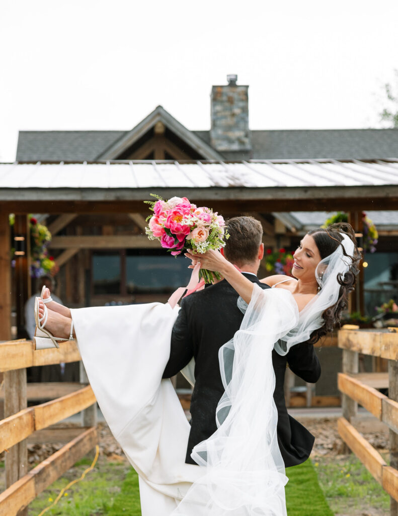 Bride lifted joyfully by the groom, captured in storytelling photography style by Haley J Photo.