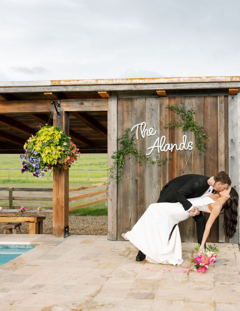 Wooden backdrop with "The Alands" sign, adding a personal touch to Montana wedding photography.