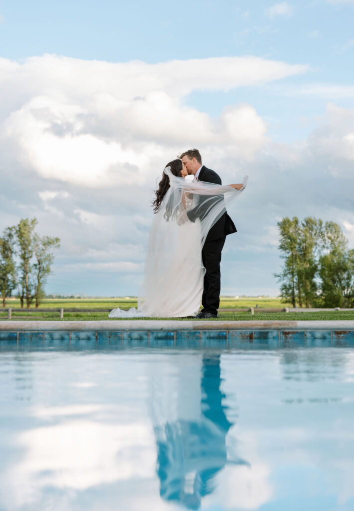 Groom playfully dipping the bride near the pool, shot by Haley J Photo.