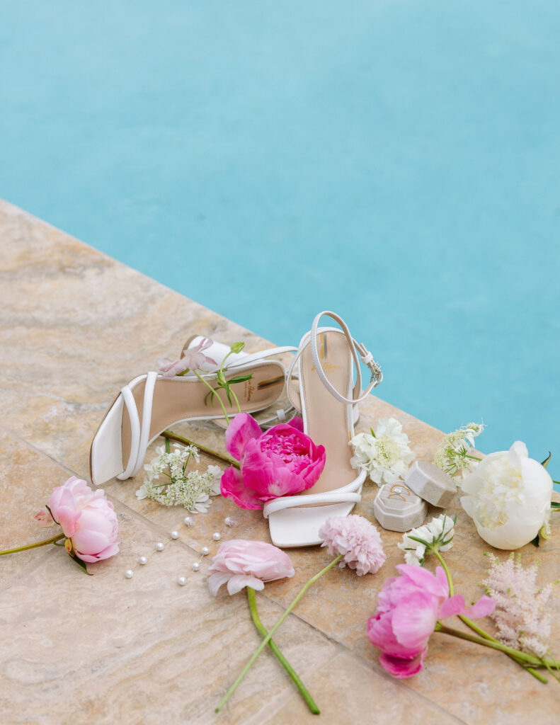 Close-up of pink and white flowers by the pool, adding elegance to storytelling wedding photography.