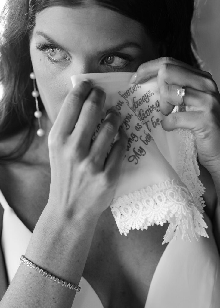 Bride wiping away a joyful tear with a handkerchief, a tender moment in storytelling photography by Haley J Photo.