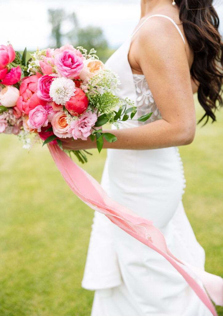 Bride holding a vibrant pink bouquet, showcasing the beauty of Montana wedding.