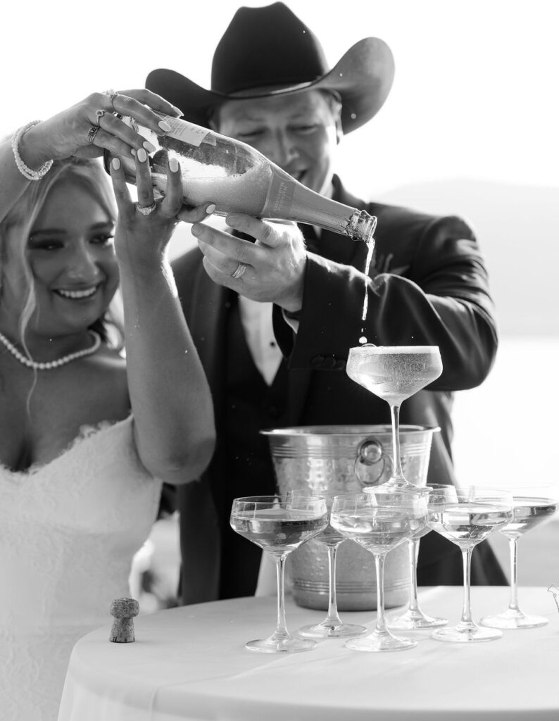 Bride and groom toast champagne tower at joyful Whitefish Montana wedding