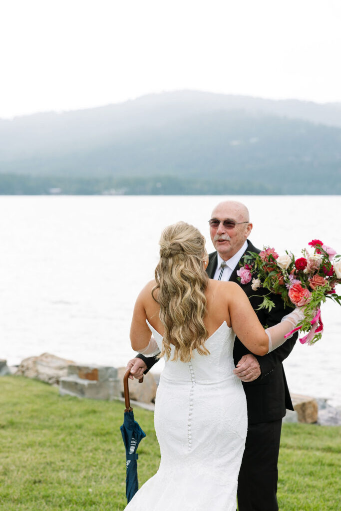 Bride hugs her father before ceremony at Whitefish Montana lakeside venue