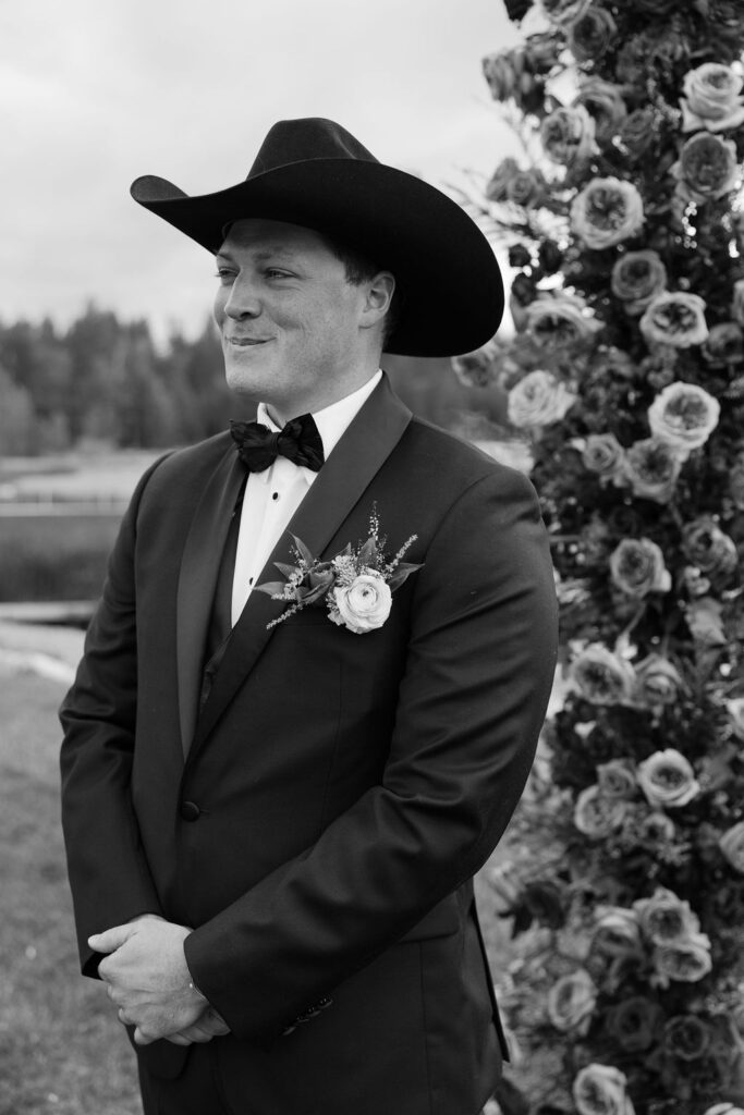 Groom smiles emotionally during ceremony at lakeside Whitefish Montana wedding