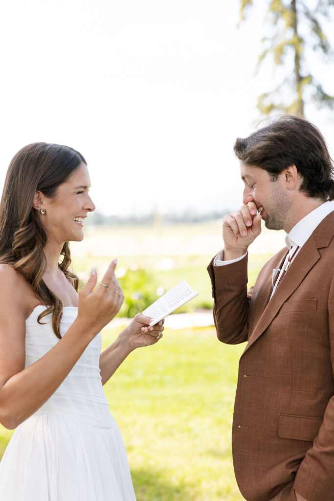 Bride reads vows to the groom with joyful emotion during an intimate ceremony moment on a sunny Montana wedding day.