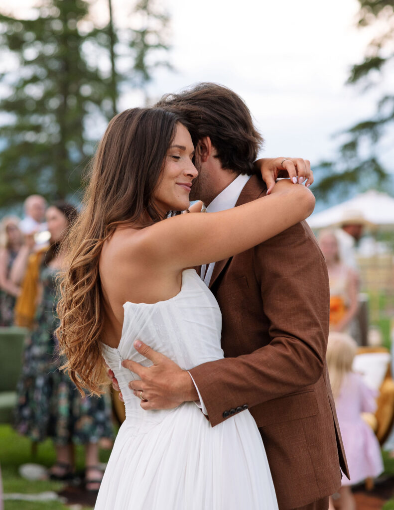 Close-up of the bride smiling as she dances with the groom during their first dance — a tender and joyful wedding moment in Whitefish, Montana.