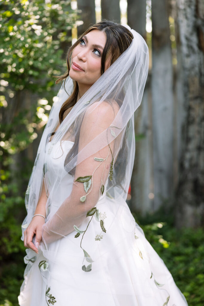 Bride smiling softly in her embroidered veil and strapless gown during her Rockin’ TJ Ranch wedding in Bozeman.