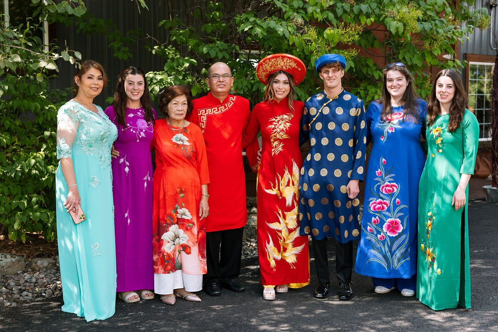 Bride and groom posing with family members in colorful traditional Vietnamese ao dai at Rockin’ TJ Ranch wedding in Bozeman, Montana.