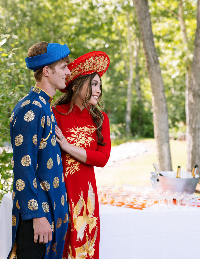Bride and groom in traditional Vietnamese ao dai sharing a moment during their wedding reception at Rockin’ TJ Ranch in Bozeman.