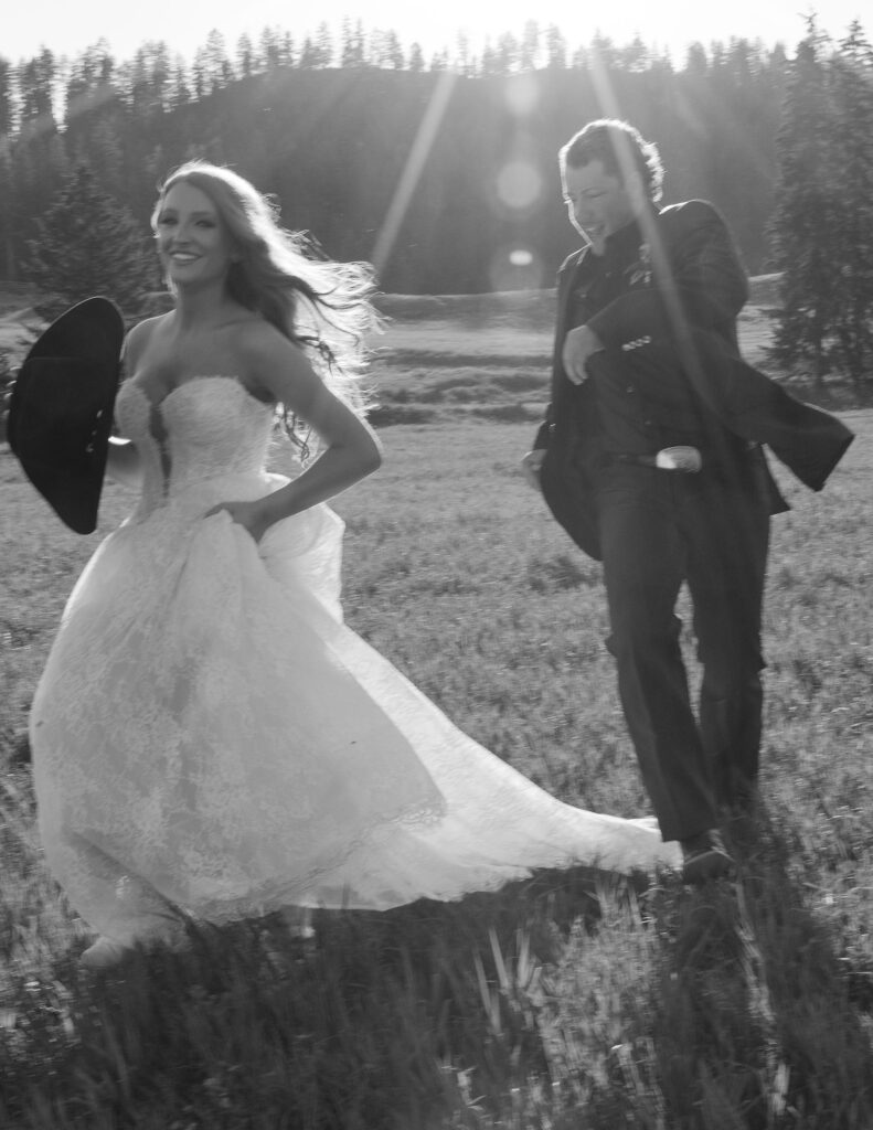 Bride holding her cowboy hat while smiling at the groom during their rustic Montana elopement at Clydesdale Outpost.
