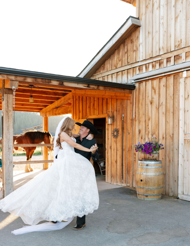 Bride and groom exchanging vows in front of the rustic barn at Clydesdale Outpost, surrounded by Montana’s natural beauty.
