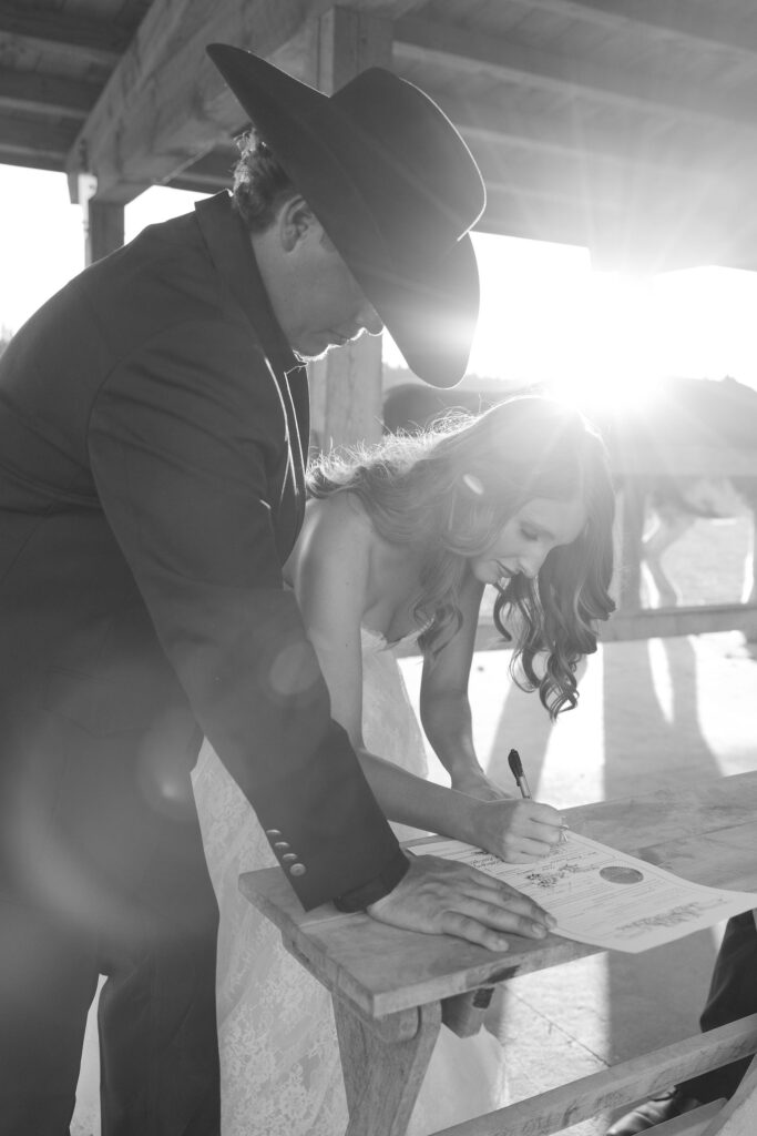 Bride and groom signing their wedding certificate.