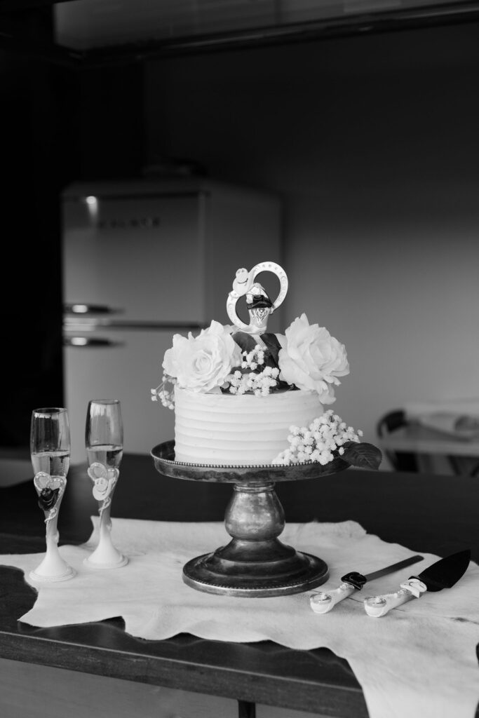 Bride and groom sharing a sweet moment cutting their wedding cake inside the cozy cabin at Clydesdale Outpost in Whitefish, Montana.
