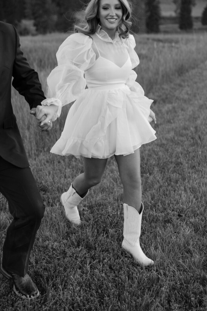 Couple embracing in the fields of Clydesdale Outpost during their Montana elopement, with rolling hills and golden hour light in the background.