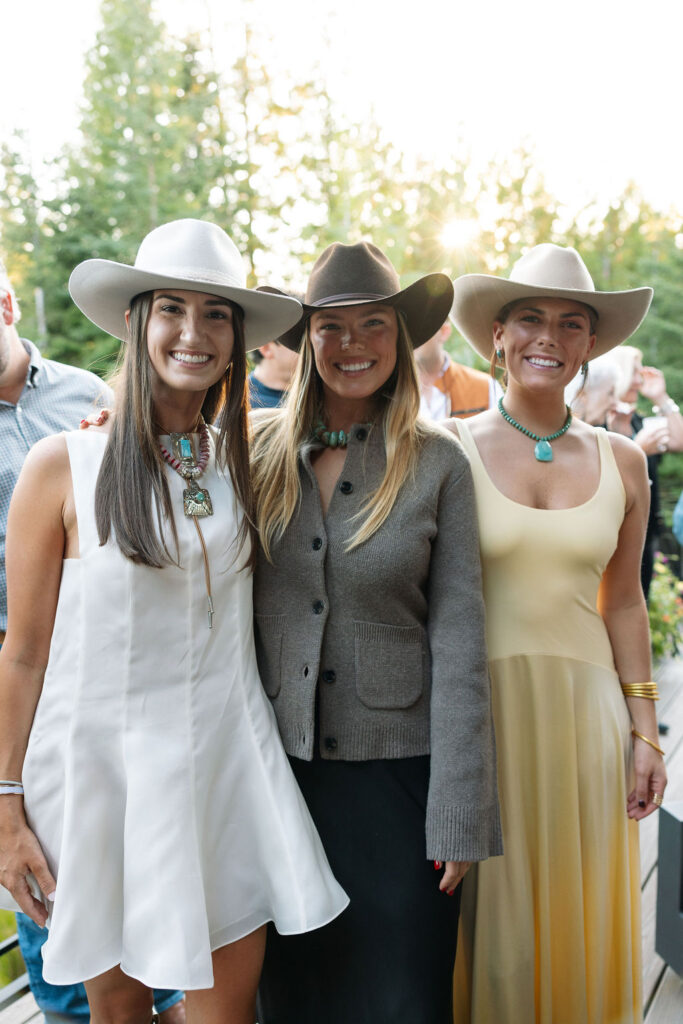 Group of three women posing together in western-inspired outfits
