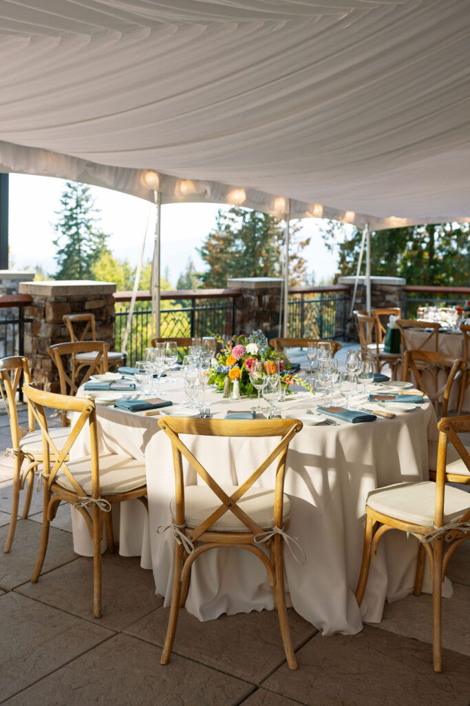 Rehearsal dinner tent with round tables and floral centerpieces