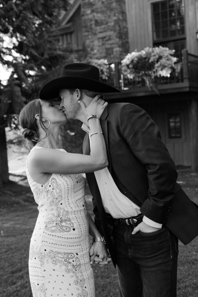 Bride kissing the groom while he wears a cowboy hat