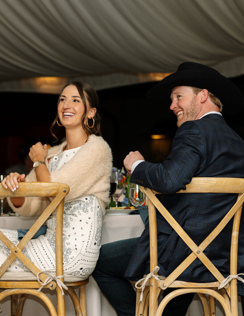 Bride smiling while sitting beside the groom during the rehearsal dinner