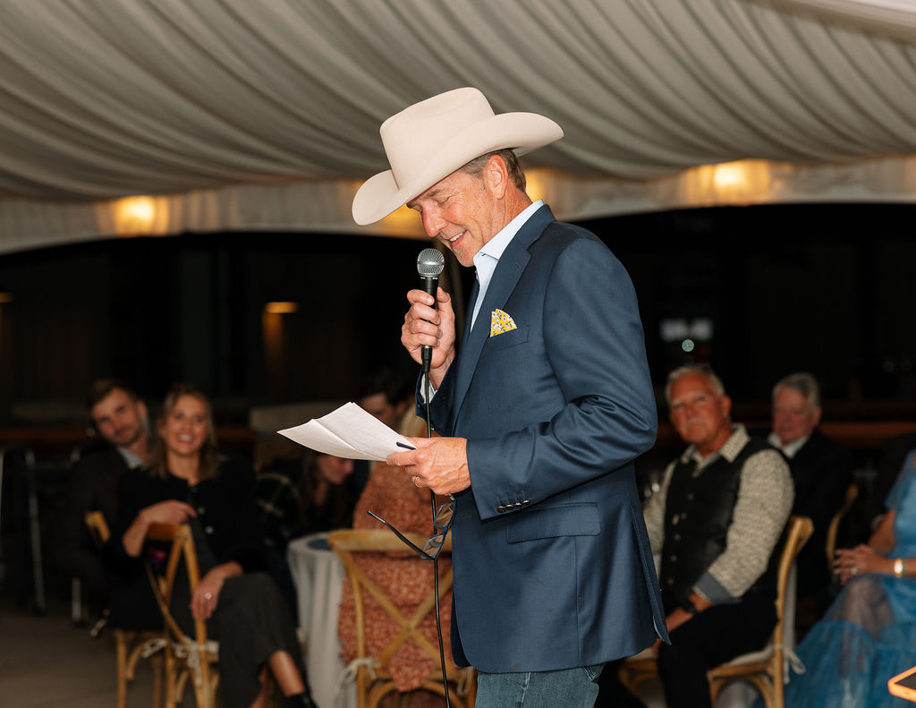 Man giving a speech in a cowboy hat during the rehearsal dinner
