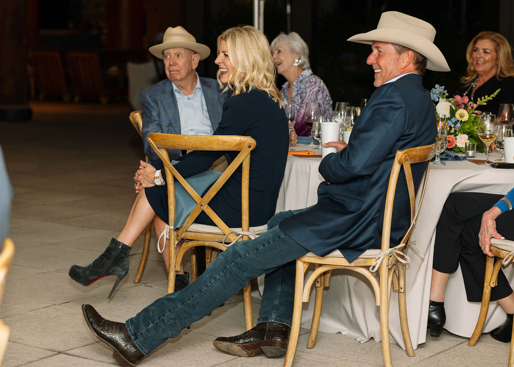 Guests seated at tables listening during the rehearsal dinner