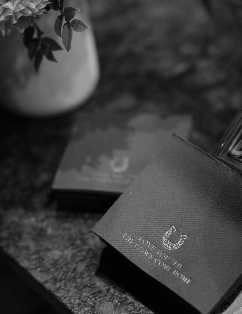 Black and white photo of wedding welcome sign styled with floral accents