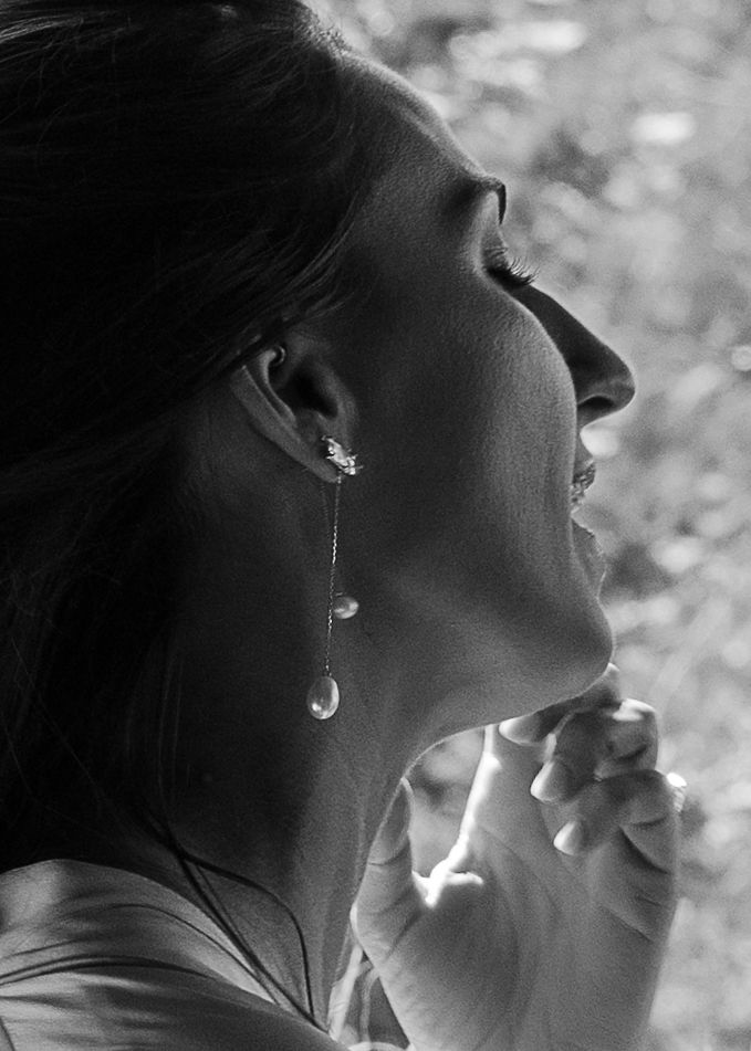 Bride smiling while getting ready as someone applies her makeup