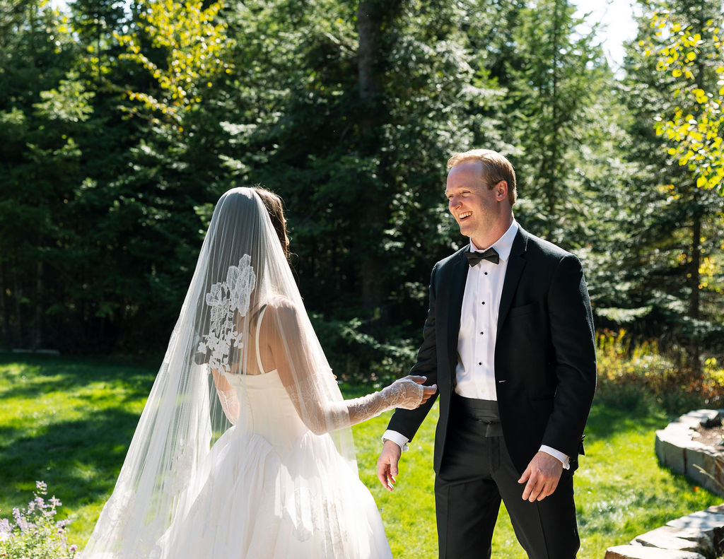 bride walking outdoors with her veil trailing behind her in the trees